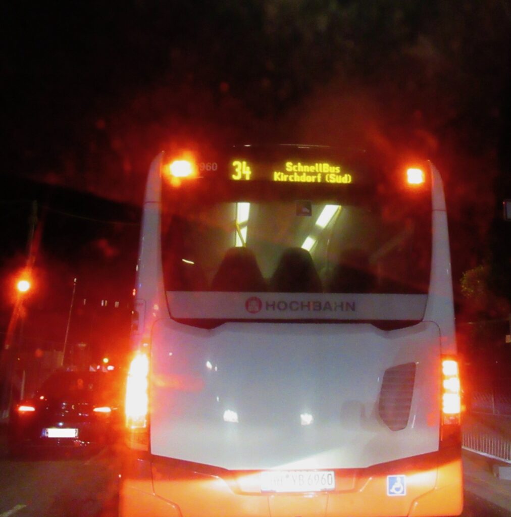 Auf dem Fote sieht man einen Bus der Linie 34 von hinten am späten Abend im Dunkeln.