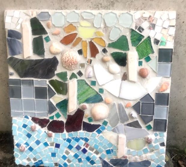 Ein buntes, fröhliches Mosaik mit ganz vielen Formen, z. B. ein Segelboot, eine Sonne, eine Windmühle. Dazwischen einige Muscheln.