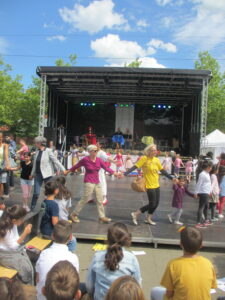 Vor Bühne tanzen viele Menschen im Kreis.