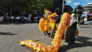Auf dem Marktplatz von Kirchdorf-Süd verkleiden sich mehrere Menschen zu einem Drachen.
