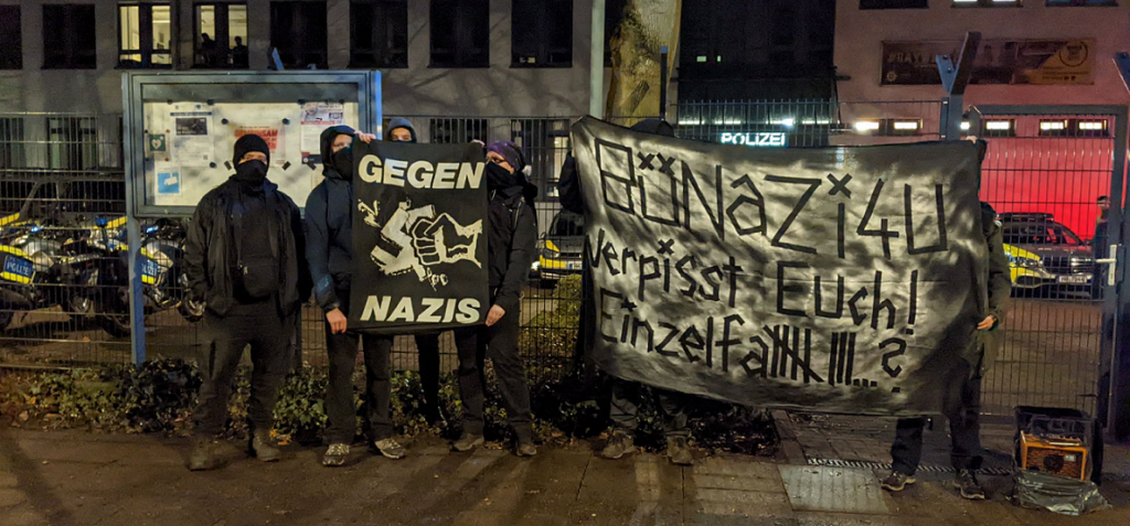 Demontrierende protestieren mit Transparenten gegen rechte Umtriebe im PK 44. Daruf steht "Gegen Nazis" und "BüNazi4U, verpisst euch! Einzelfall 8?"