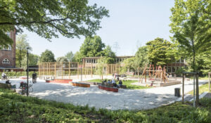 Quartiersplatz Georgswerder: Ein Spielplatz mit Holzgerüsten, drum herum ein Weg mit Bänken und Bäume,