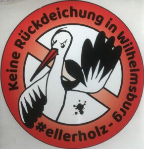 Logo gegen die Rückdeichung in Wilhelmsburg. Runder roter Kreis mit einem Querbalkon von links oben nach rechts unten. Davor ein Storch mit abwehrendem linken Flügel.