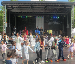 Viele Menschen tanzen im Kreis vor der Bühne auf dem Marktplatz in Kirchdorf Süd.