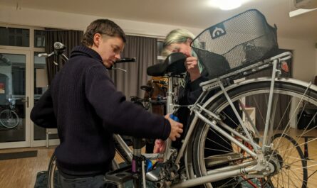 Zwei Personen an einem aufgebockten Fahrrad