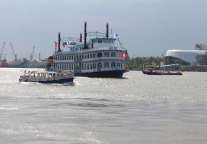 Eine Barkasse auf der Elbe, davor ein kleineres Boot.