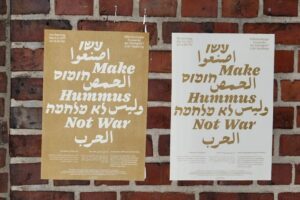 An einer Backsteinwand hängen 2 Plakate mit der Veranstaltungsankündigung auf englisch, hebräisch und arabisch.
