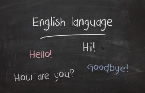 Auf einer Tafel steht "English language" und "Hello", "Hi!", "How are you?" und "Goodbye"