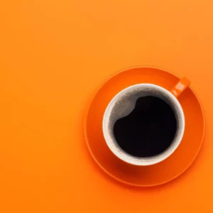orangenes Bild, darauf eine Kaffeetasse aus der Vogelperspektive.