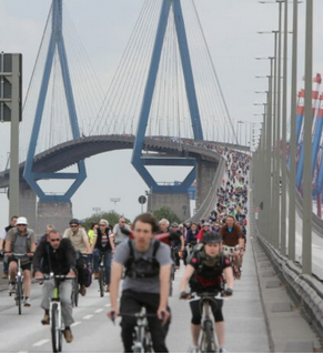 Viele Radfahrer fahren ber die Köhlbrandbrücke auf den Fotografen zu