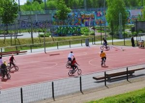 Menschen fahren auf einem Basketballfeld Fahrrad
