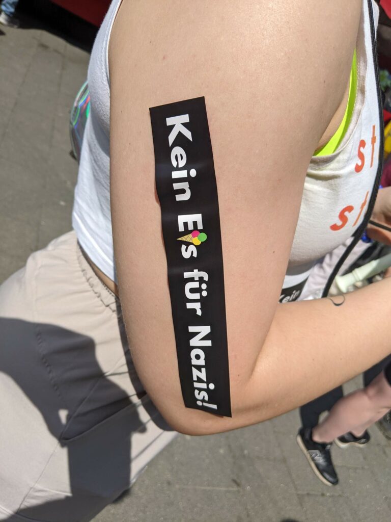 auf einem Arm klebt ein Sticker mit der Aufschrift "Kein Eis für Nazis"