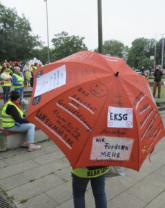 Ein großer roter Regenschirm mit Parolen beschrieben. 