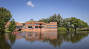 Das Bürgerhaus Wilhelmsburg unter blauem Himmel, im Wasser davor ein Kajak