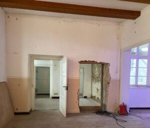 Ein entkerntner Raum im Museum. In einer weißen Wand zwei Türen, rechts in einem weiteren Raum ein Fenster.