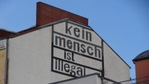 Eine Häuserwand auf der steht "Kein Mensch ist illegal"