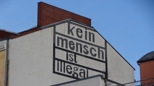 Eine Häuserwand auf der steht "Kein Mensch ist illegal"