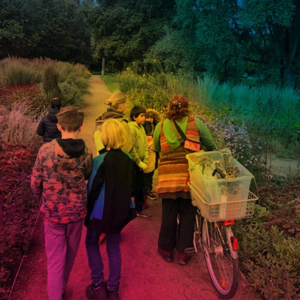 Menschen zu Fuß und mit einem Fahrrad auf einem Feldweg,