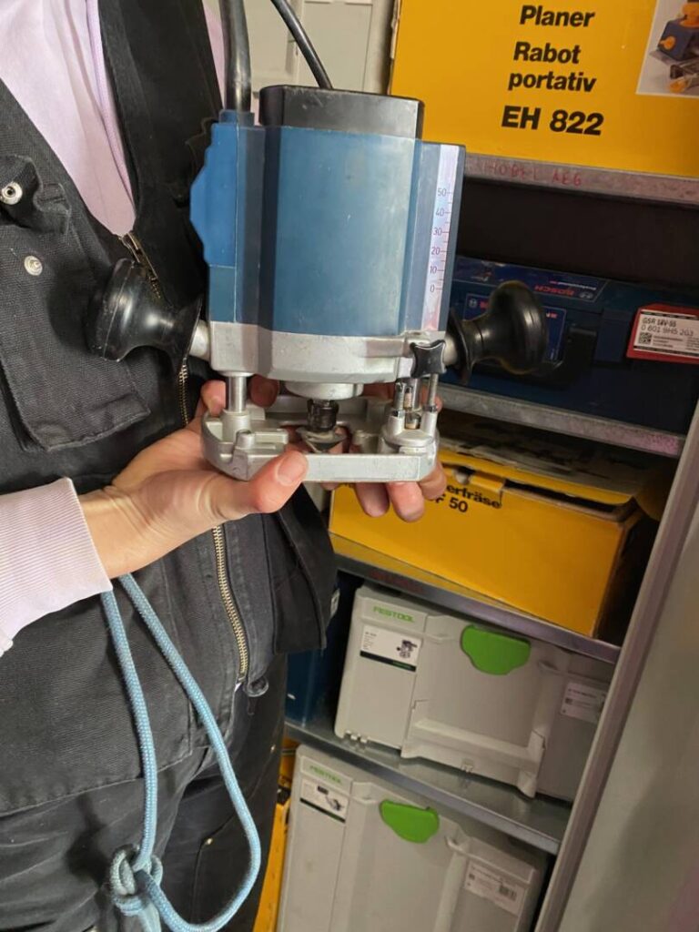 Eine Hand hält eine blaue Maschine.
