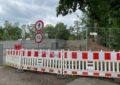 Baustellenabsperrung vor einer Betonmauer