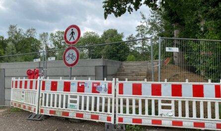 Baustellenabsperrung vor einer Betonmauer