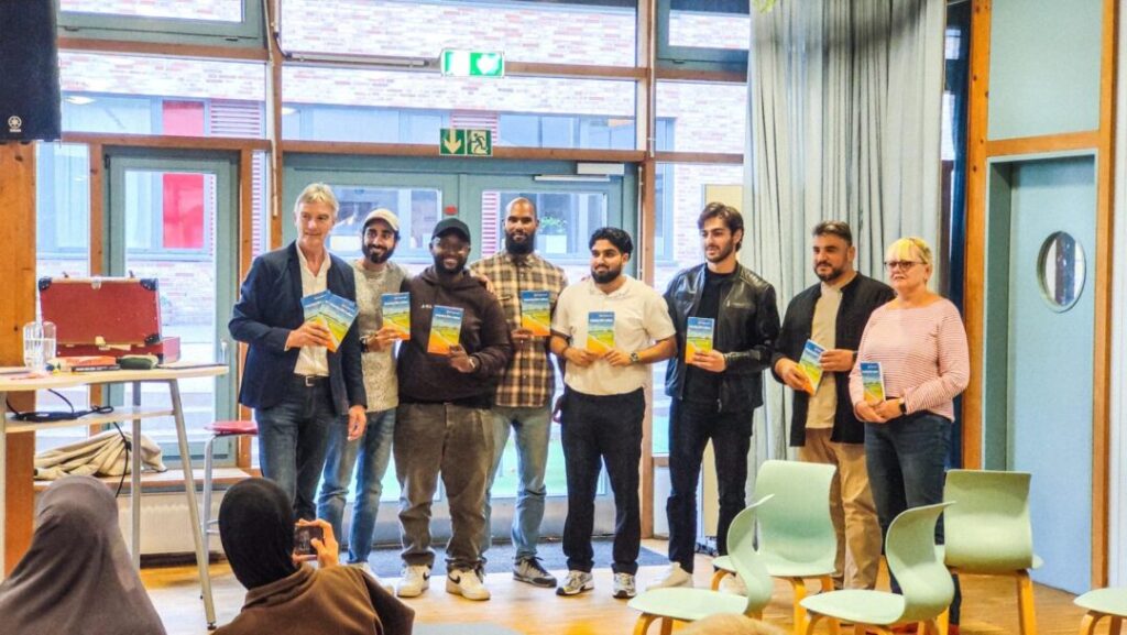 Wilhelm Kelber-Bretz undn einge der Interviewten stehen nebeneinander und halten das Buch vor sich.