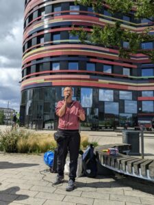 Eine Person steht mit einem Mikro in der Hand vor der Behörde für Stadtentwicklung und Wohnen.
