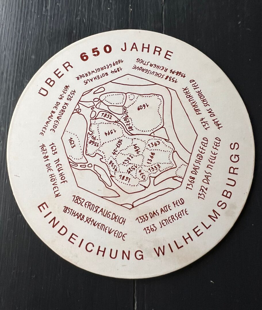 Weißer Bierdeckel auf schwarzem Grund mit Zeichnung der Elbinseln und Beschriftung