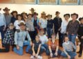 Gruppenfoto: Die Büwi Line Dancers (ca. 20 von ihnen) posieren vor einer Wand. Alle tragen Cowboy-Hüte, aber sie haben normale Kleidung an, nicht wie bei den Auftritten alle ein weißes Hemd. Foto: Melanie Brito