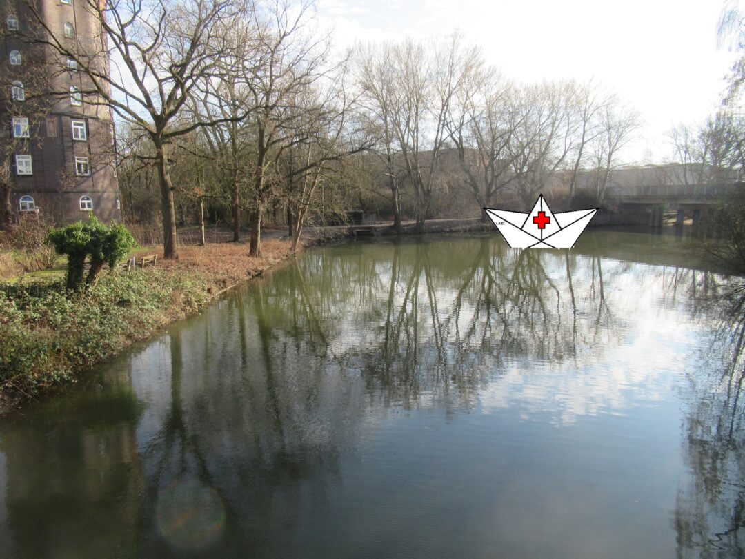 Blck auf den Veringkanal, links am Rabd der Wasserturm, im Hintergrund ins Bild montiert ein großes Papierschiff mit rotem Kreuz in der Mitte 
