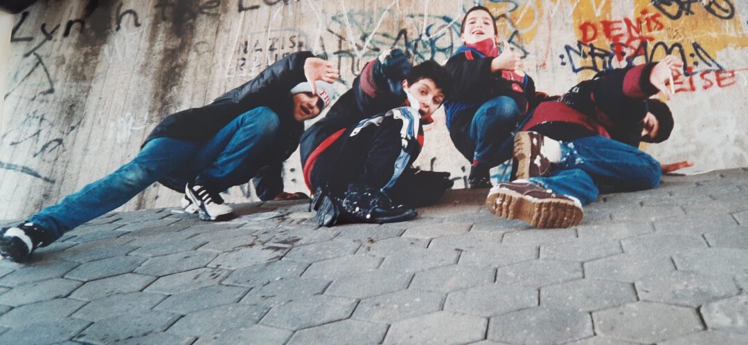 eine Grupoe von vier Jungen, die auf einer schrägen Wand hockt