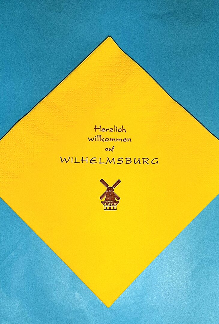 Eine gelbe Serviette diagonal auf blauem Grund.