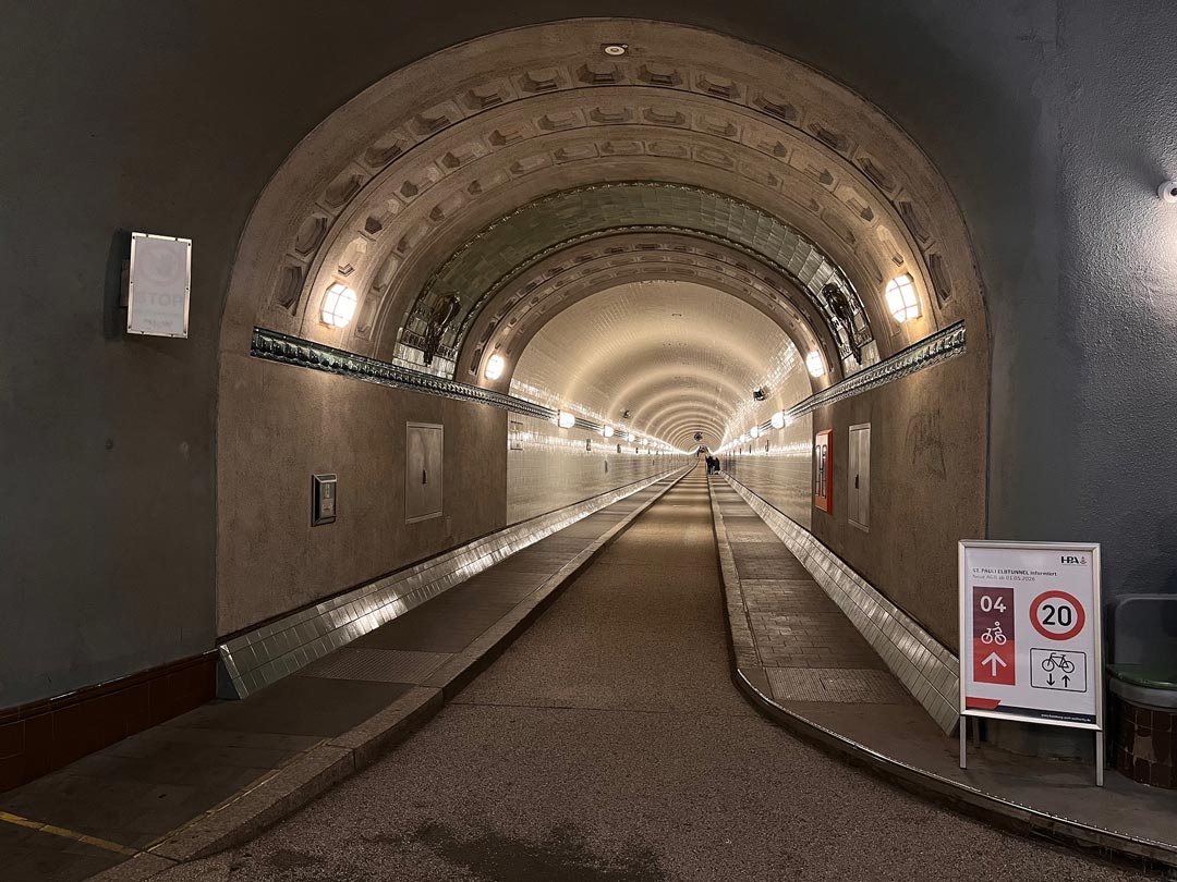 Blick in die Oströhre, am Anfang rechts ein Schild, das darauf hinweist, dass der Tunnel zur Radroute 4 gehört.