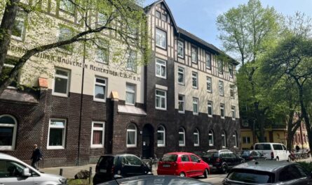 Fassade des Bauvereins Reiherstieg in der Fährstraße: Unten dunkel geklinkert, oben hell gestrichen, ganz oben eine Art (oder tatsächliches Fachwerk mit dunklen Balken)
