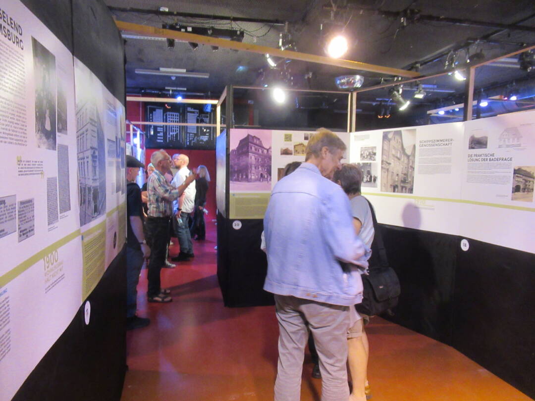 Mehrere Besucher*innen vor den Ausstellungswänden