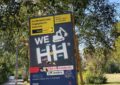 Vor grünem Laub steht ein Baustellenschild von Hamburg