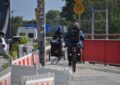 Blick auf den letzten Teil des Radweges auf den Neuen Elbbrücken stadteinwärts: Eine Radlerin mit Hänger fährt weiter vorn, es passt, aber viel Platz ist nicht, dahinter ein Radler auf einem normalen Zweirad.
