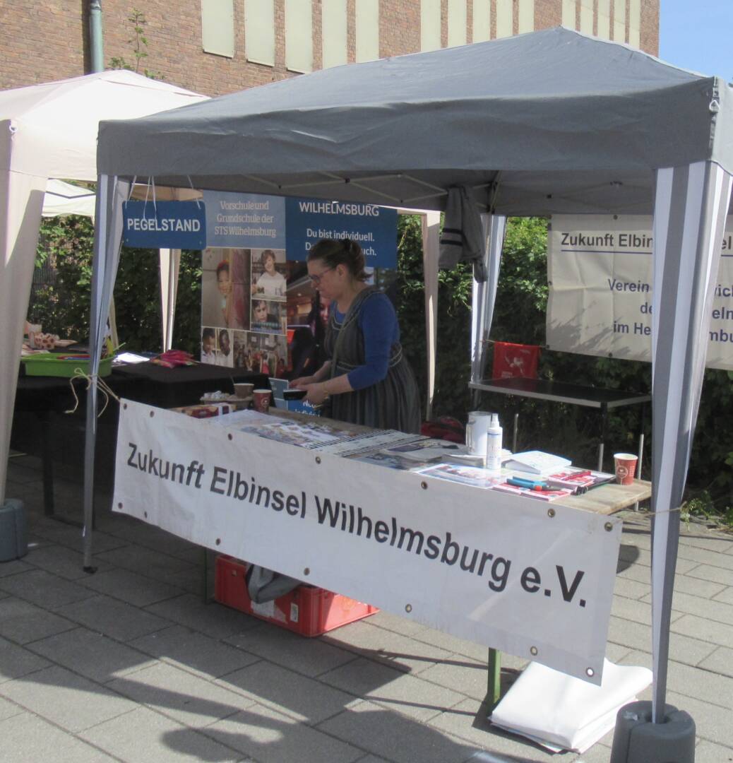 Ein 3 x 3 Meter großer Gartenpavillon, darunter der Infostand von Zukunft Elbinsel, mit einer Person.